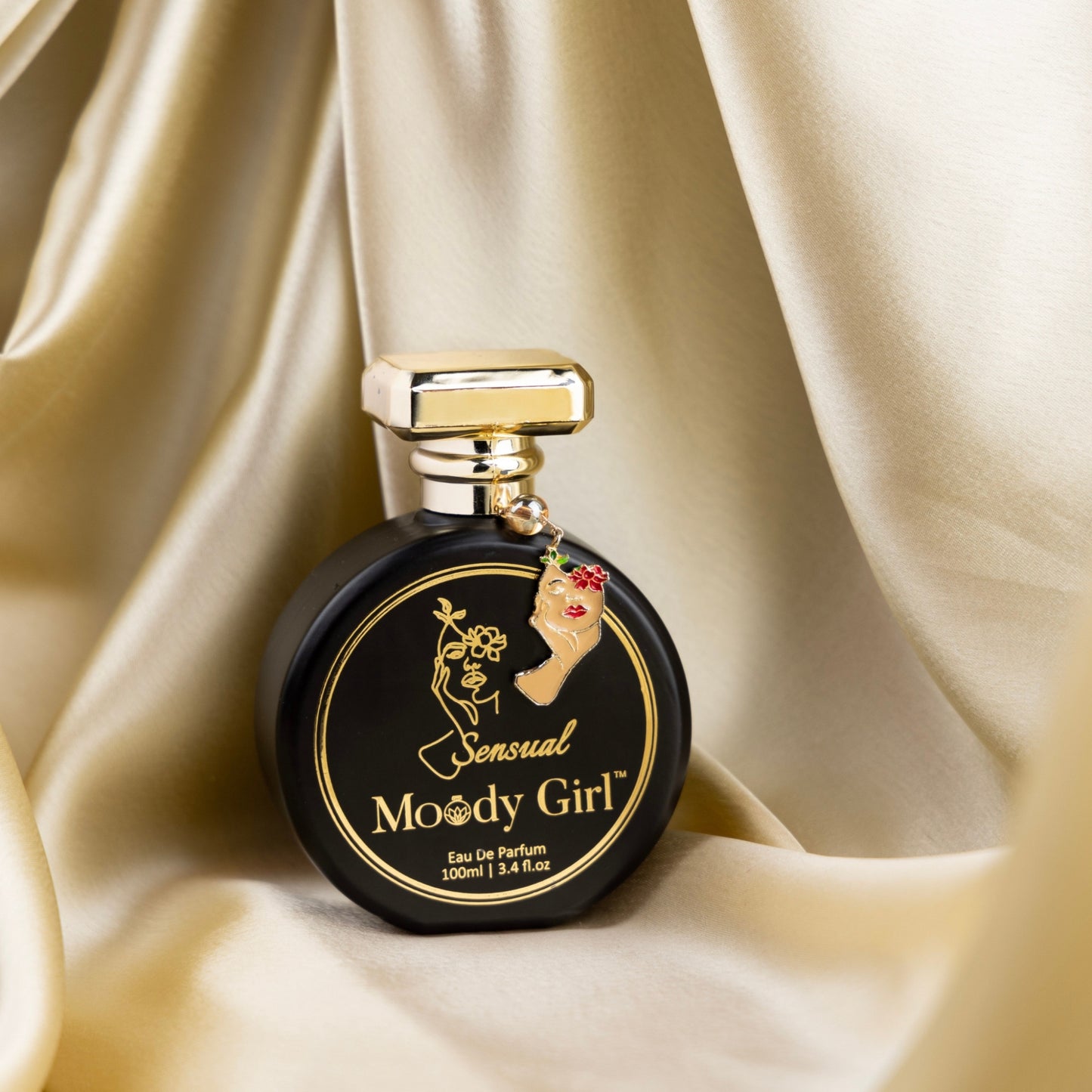 Perfume bottle labeled 'Sensual Moody Girl' on a beige fabric background