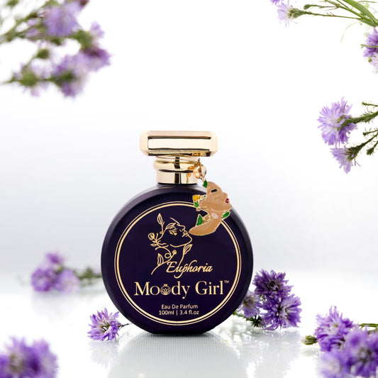 Moody Girl Euphoria 100ml Perfume bottle labeled 'Moody Girl' with gold cap on a white background with purple flowers.